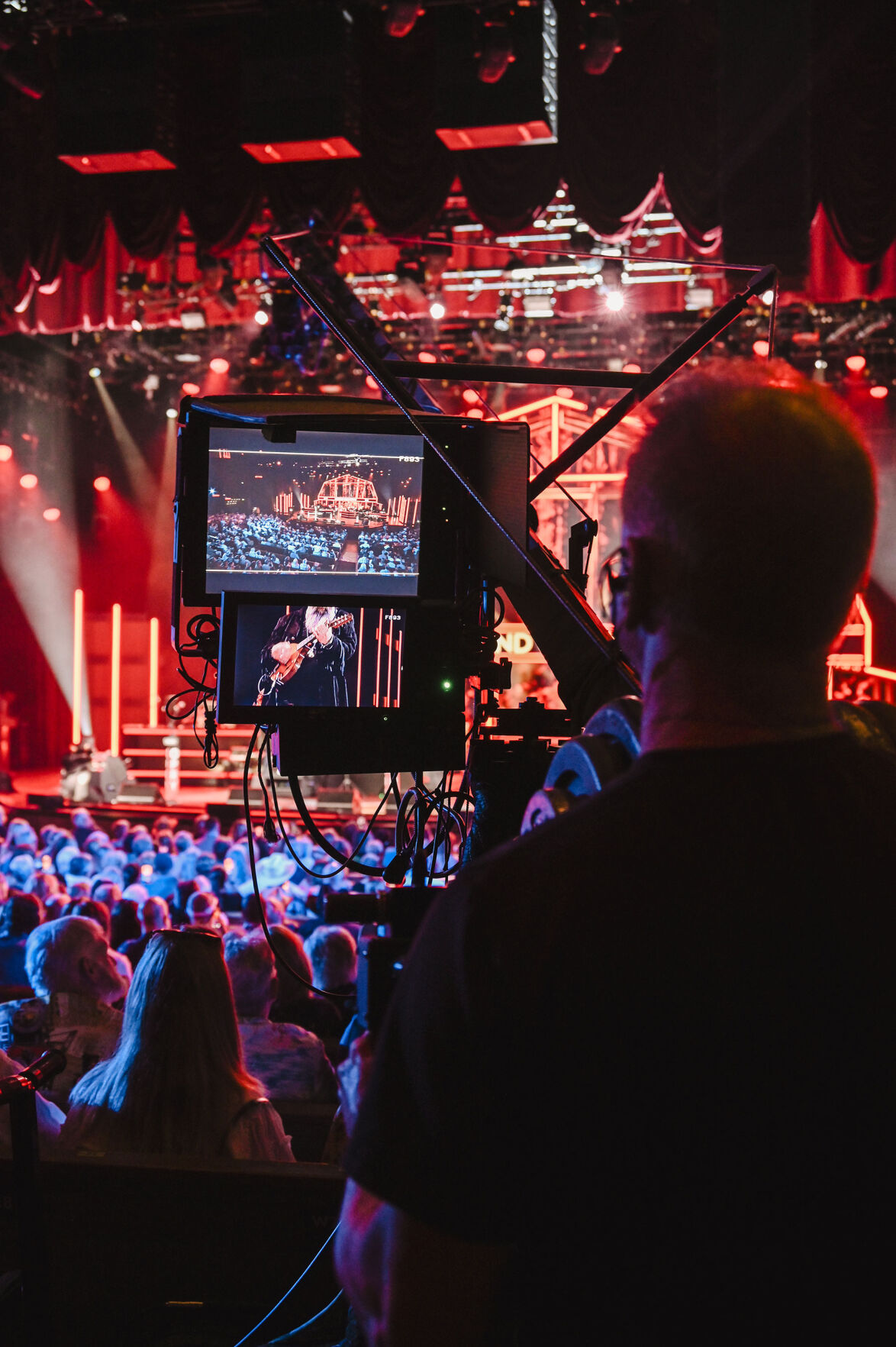 A camera films Steve Earle on stage at the Grand Ole Opry